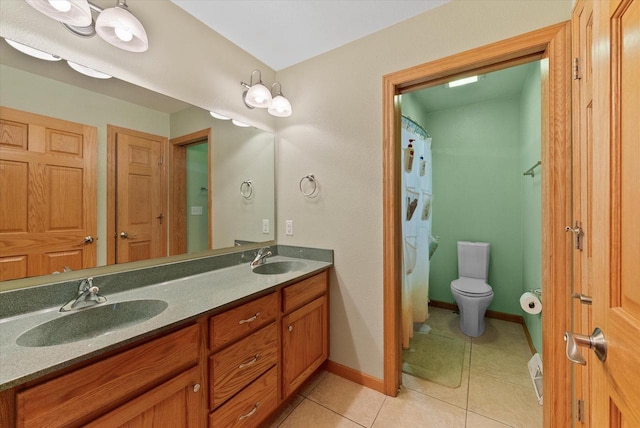 bathroom with double vanity, tile patterned flooring, a sink, and toilet