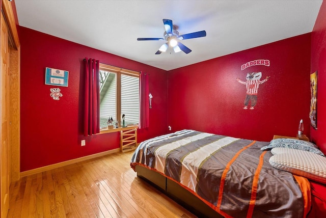 bedroom with wood-type flooring, a ceiling fan, and baseboards