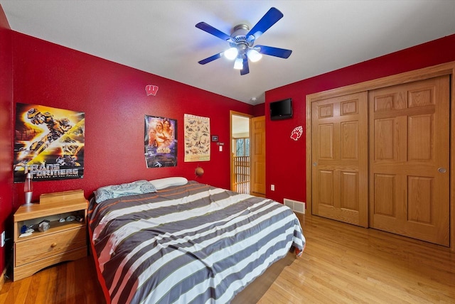 bedroom featuring baseboards, ceiling fan, visible vents, and wood finished floors