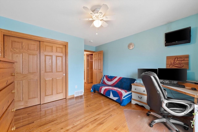 home office featuring baseboards, light wood-style flooring, visible vents, and a ceiling fan