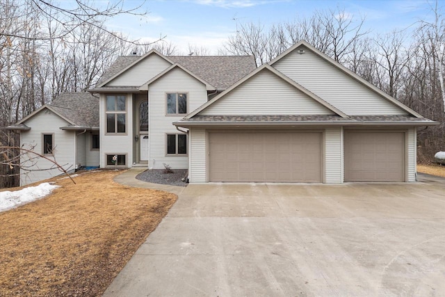 view of front of house featuring a garage, concrete driveway, and roof with shingles