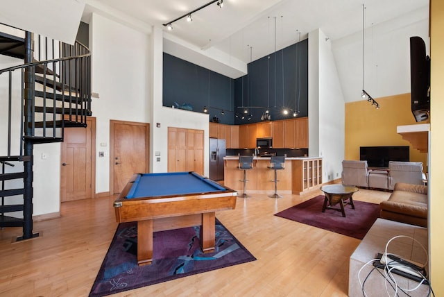 playroom with billiards, baseboards, a towering ceiling, rail lighting, and light wood-type flooring