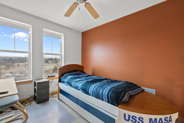 carpeted bedroom featuring ceiling fan and visible vents