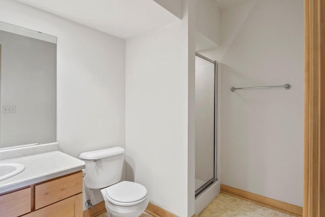 bathroom with toilet, a shower stall, baseboards, and vanity