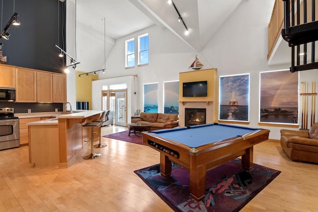 rec room with high vaulted ceiling, pool table, and light wood-type flooring