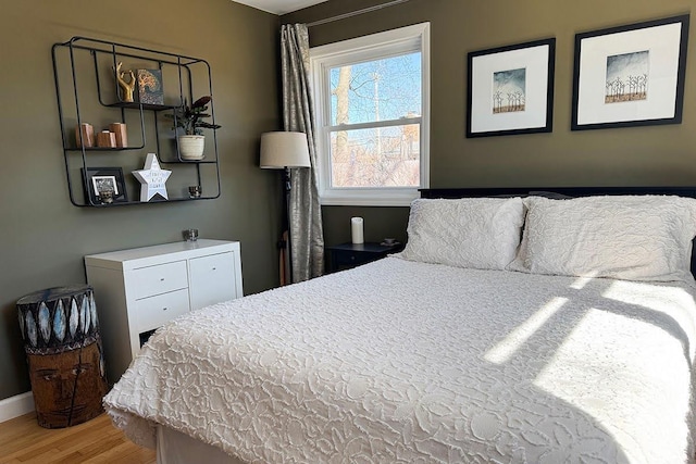 bedroom featuring baseboards and wood finished floors