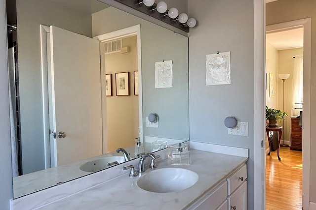 bathroom with wood finished floors, vanity, and visible vents