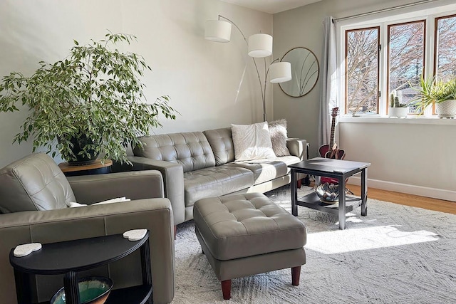 living area with baseboards and wood finished floors