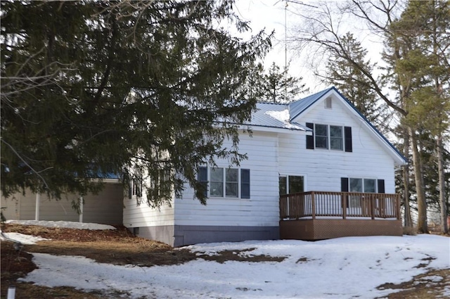 view of front of property with a garage, metal roof, and a wooden deck