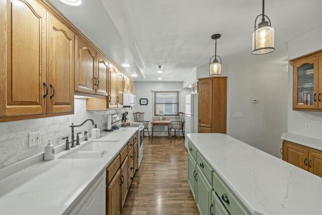 kitchen featuring backsplash, dark wood-type flooring, a sink, light stone countertops, and white appliances