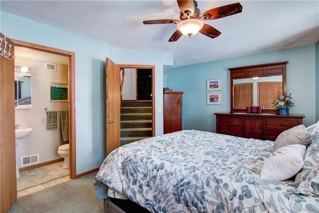 bedroom featuring a textured ceiling, carpet floors, visible vents, and baseboards