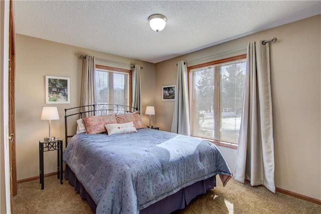 bedroom with light carpet, a textured ceiling, and baseboards