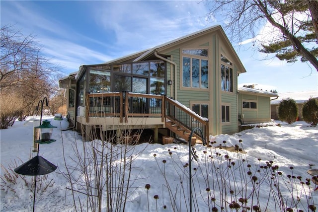 snow covered house with a wooden deck