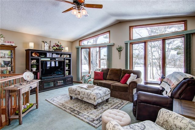 living area featuring lofted ceiling, a textured ceiling, a ceiling fan, and carpet flooring