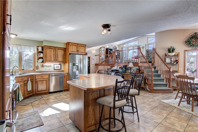 kitchen featuring stainless steel appliances, plenty of natural light, a center island, and a kitchen breakfast bar