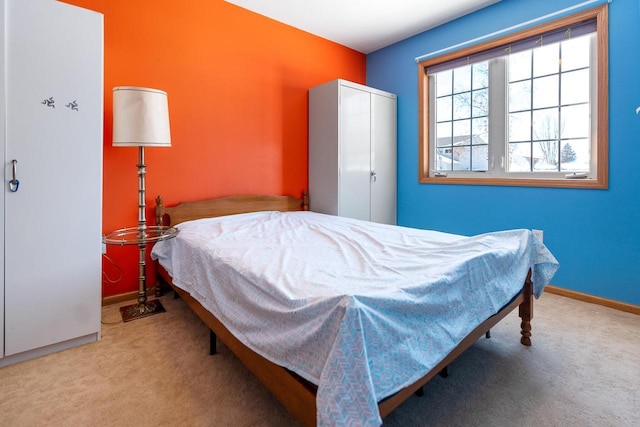 carpeted bedroom with baseboards and a closet