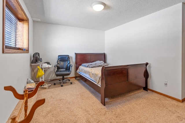 bedroom featuring carpet floors, baseboards, and a textured ceiling