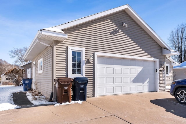 snow covered property featuring concrete driveway