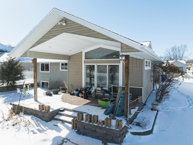 snow covered property featuring a patio