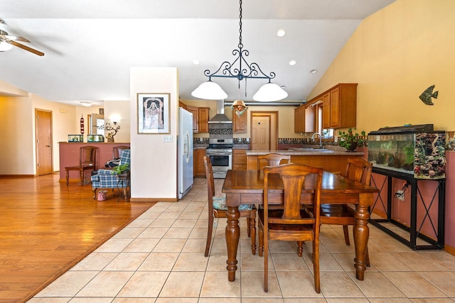 dining room with baseboards, ceiling fan, vaulted ceiling, light wood-type flooring, and recessed lighting