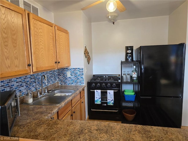 kitchen featuring tasteful backsplash, a ceiling fan, dark countertops, black appliances, and a sink