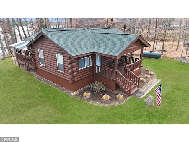 exterior space featuring stairs, a front yard, log siding, and roof with shingles