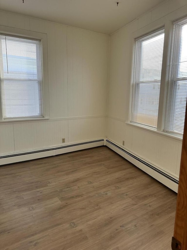 empty room featuring a baseboard heating unit and light wood-style flooring