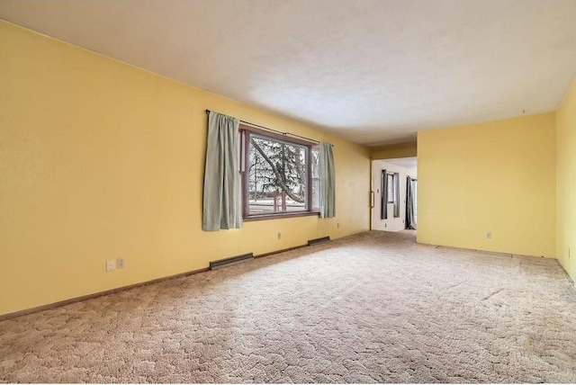 unfurnished room featuring carpet, visible vents, and baseboards