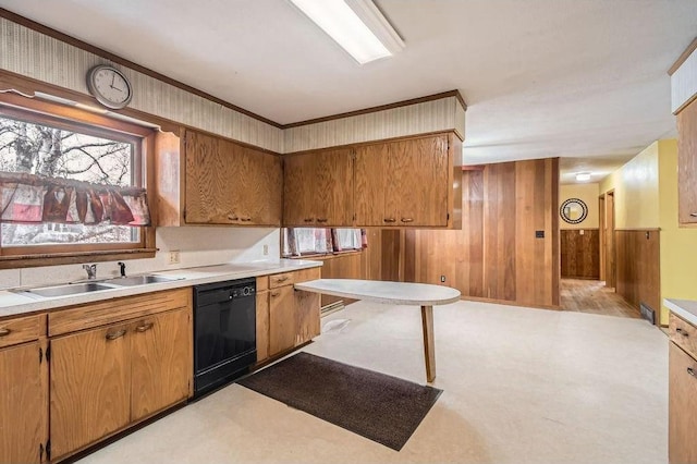 kitchen with wooden walls, a sink, black dishwasher, light countertops, and brown cabinets