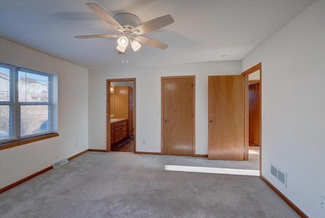 unfurnished bedroom featuring carpet flooring, visible vents, connected bathroom, and baseboards