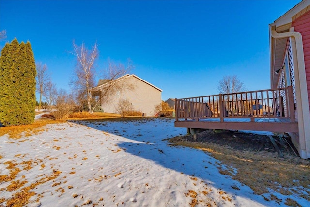snowy yard with a wooden deck