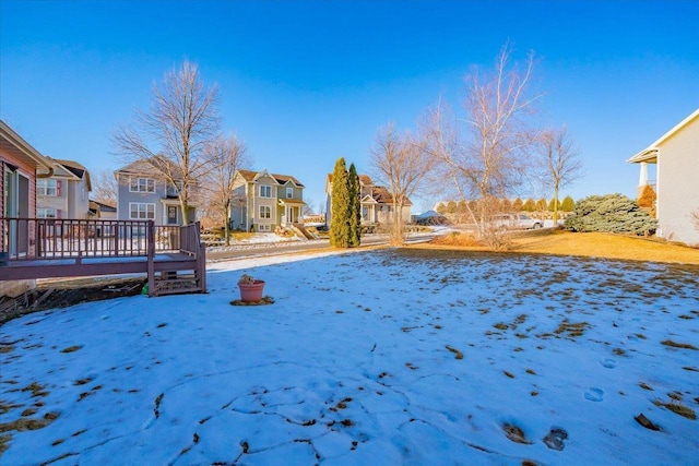 snowy yard featuring a residential view
