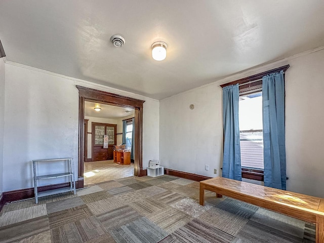 interior space featuring dark carpet and baseboards