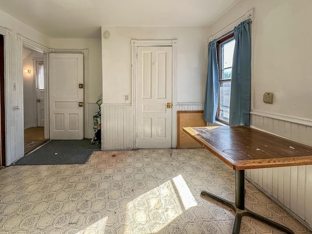 interior space featuring light floors and wainscoting