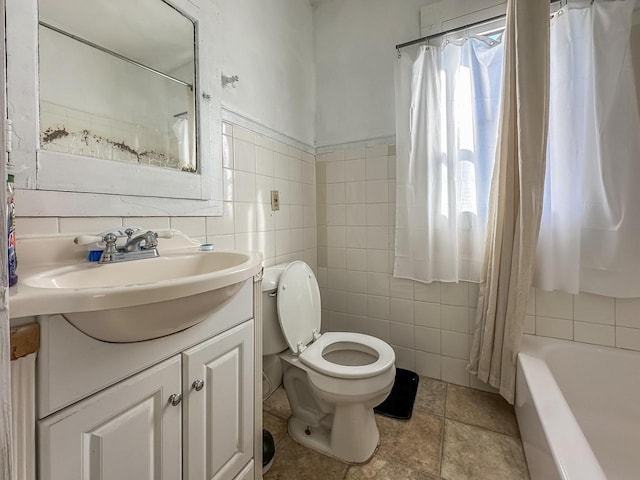 full bathroom featuring shower / tub combo, tile walls, vanity, and toilet