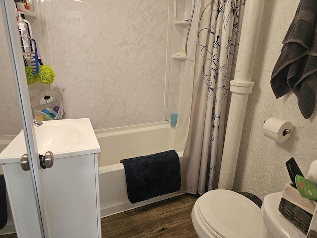 bathroom featuring a textured wall, toilet, shower / bath combo with shower curtain, vanity, and wood finished floors