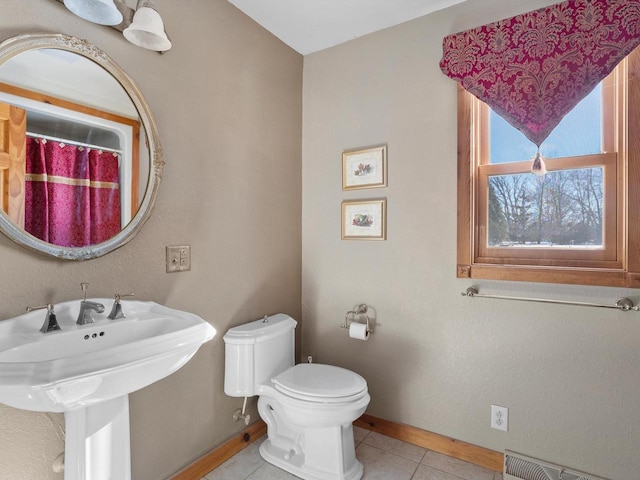 bathroom with toilet, baseboards, visible vents, and tile patterned floors