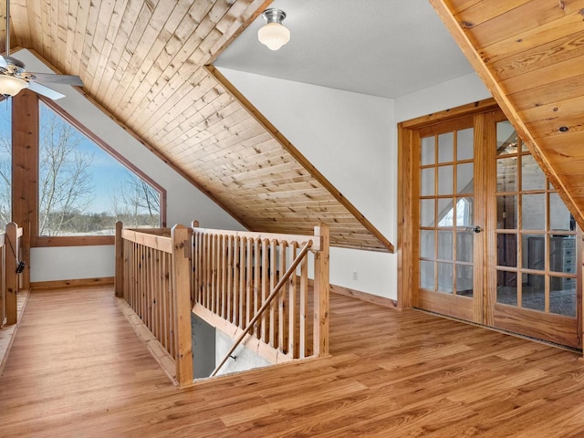 additional living space featuring french doors, lofted ceiling, wood ceiling, light wood-type flooring, and baseboards