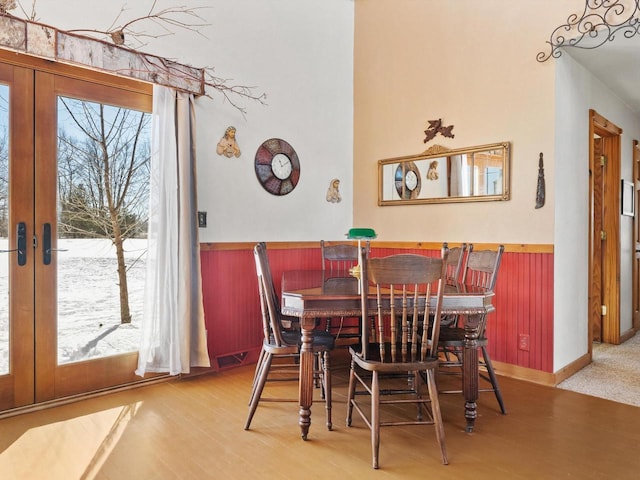 dining room featuring french doors, a wainscoted wall, visible vents, and wood finished floors