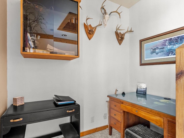 home office with baseboards and light colored carpet