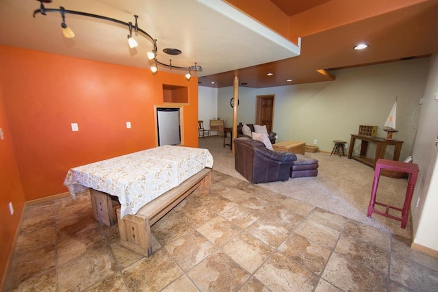 recreation room with stone finish flooring, track lighting, recessed lighting, and baseboards