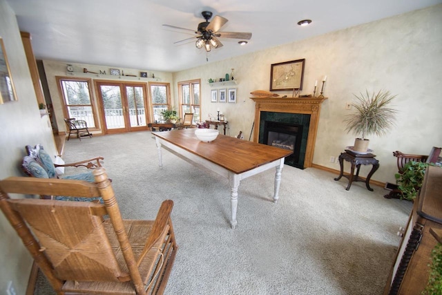 office featuring light carpet, baseboards, a ceiling fan, a glass covered fireplace, and french doors