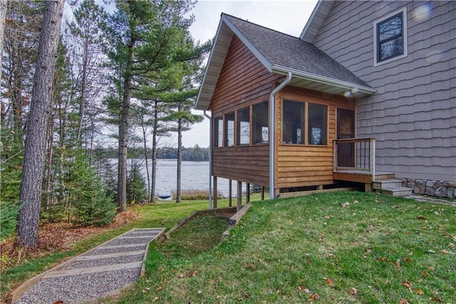 23310 Clam Lake Rd, Clam Lake, WI 54517 - view of property exterior featuring a water view, a sunroom, a lawn, and roof with shingles