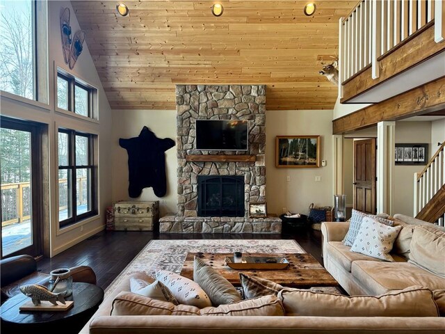 23310 Clam Lake Rd, Clam Lake, WI 54517 - living area featuring stairs, high vaulted ceiling, dark wood-type flooring, and a stone fireplace