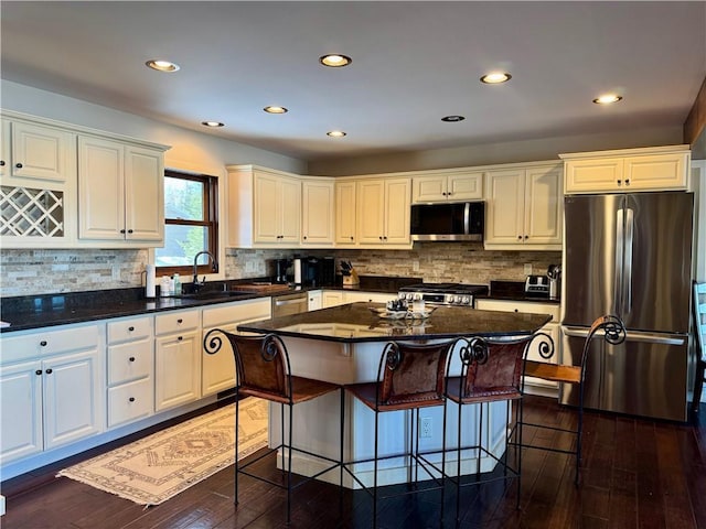 23310 Clam Lake Rd, Clam Lake, WI 54517 - kitchen with dark countertops, appliances with stainless steel finishes, dark wood-style flooring, a center island, and a sink