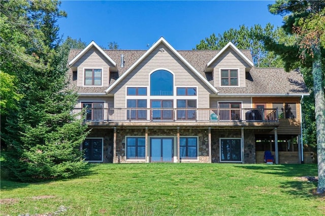 23310 Clam Lake Rd, Clam Lake, WI 54517 - rear view of house featuring a deck, stone siding, a shingled roof, and a lawn