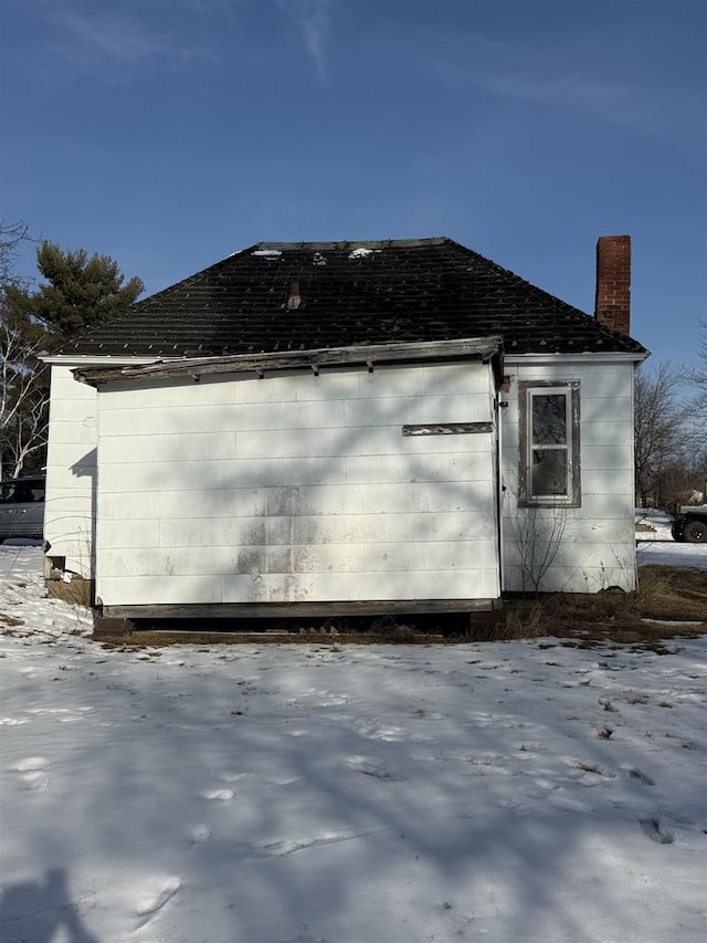 snow covered property with a chimney