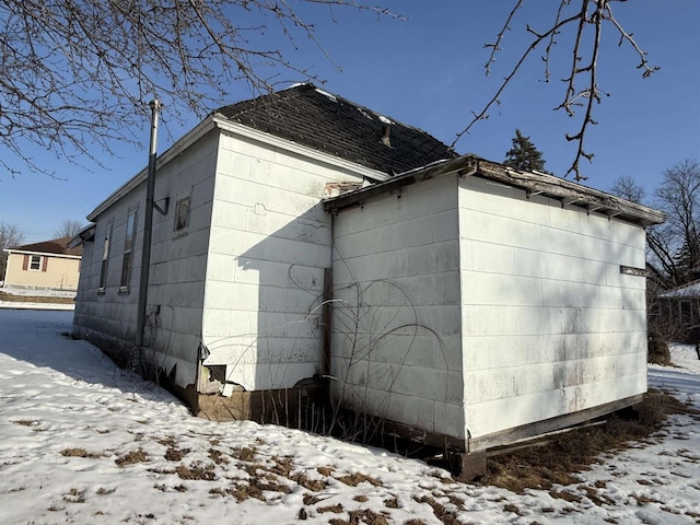 view of snow covered exterior featuring concrete block siding