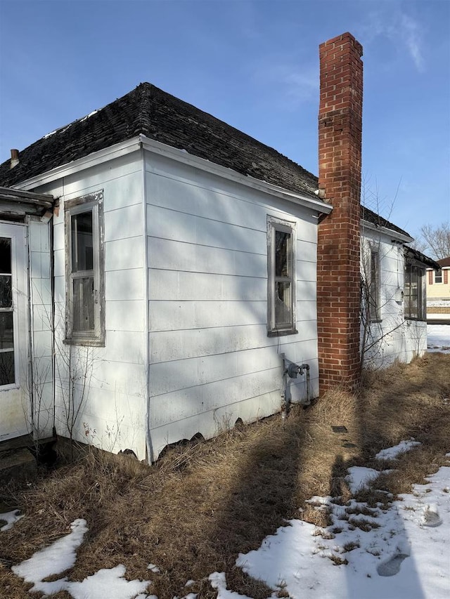 snow covered property featuring a chimney