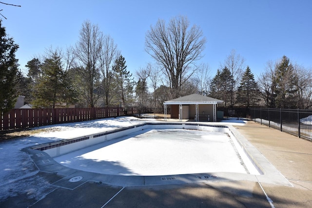 community pool featuring fence, an outdoor structure, and a patio